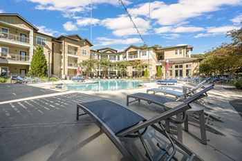 A sunny day at the outdoor pool area of a residential complex.